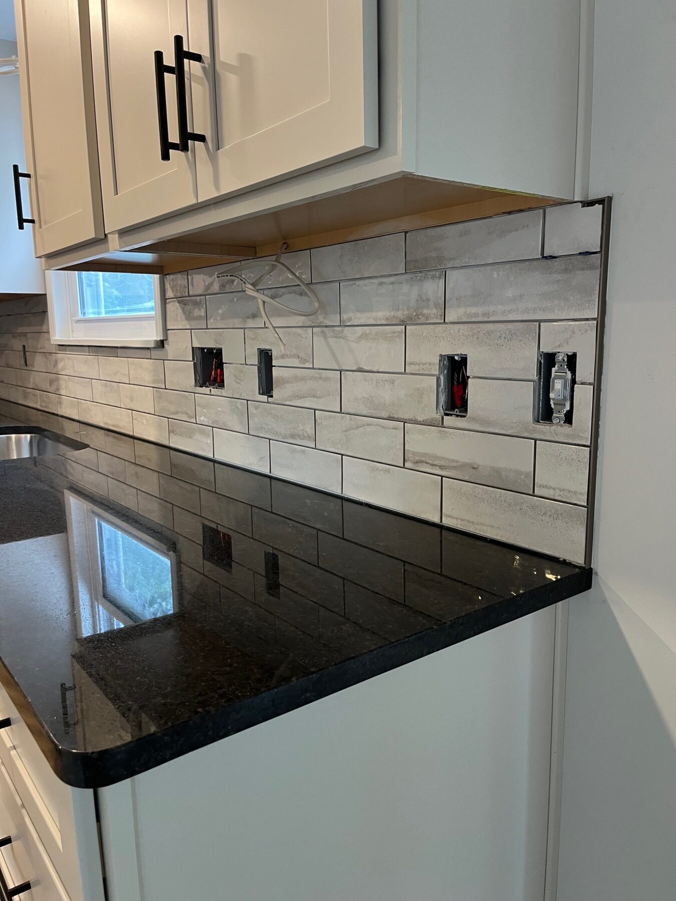 Close view of a precisely fitted gray subway tile backsplash