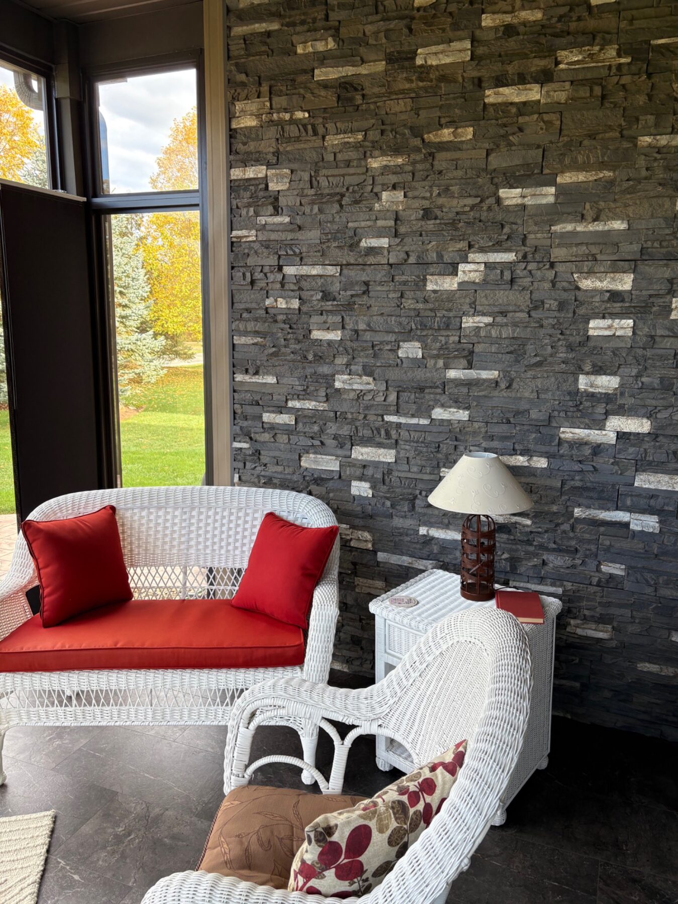 Finished dark stone accent wall in a screened sitting area